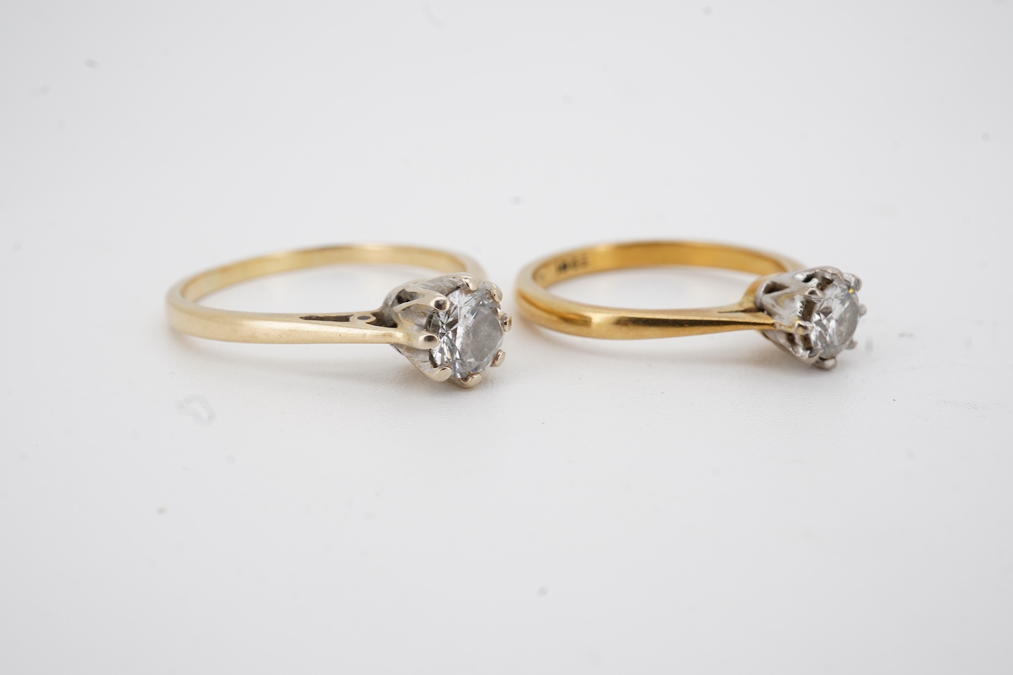 An early 1970's 18ct gold and claw set solitaire diamond ring, size K/L, the stone weighing approx. 0.33ct, together with a yellow metal and solitaire diamond ring, the stone weighing approx. 0.50ct, size P/Q, gross weig